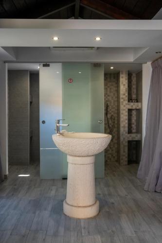 a bathroom with a sink in the middle of a room at Anagenessis Resort in Kalamaki