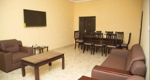 a living room with a couch and a table and chairs at Extended Stay Suite in Adentan