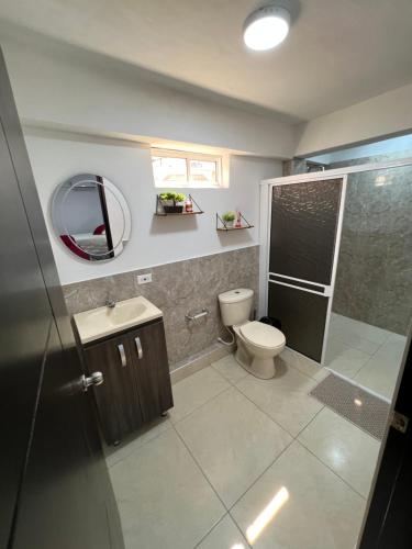 uma casa de banho com um WC, um lavatório e um espelho. em POSADA VILLA BRYAN em Providencia