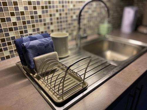 a tray with a drying rack next to a sink at Vakantiestudio Ouanaïo in Zedelgem