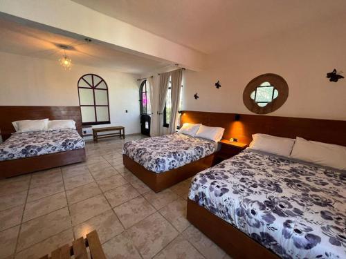 a hotel room with two beds and a mirror at Casa Lomas Grangelo in Atlixco