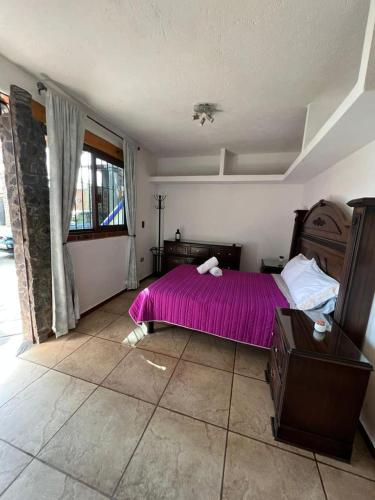 a bedroom with a bed with a purple blanket at Casa Lomas Grangelo in Atlixco