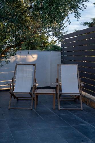 two chairs and a bench sitting next to a fence at Anagenessis Resort in Kalamaki
