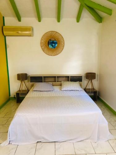 una camera da letto con un grande letto bianco in una stanza di Rêves de mer a Deshaies