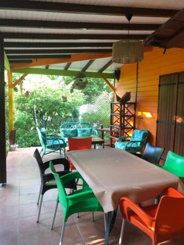 a patio with a table and colorful chairs at Rêves de mer in Deshaies