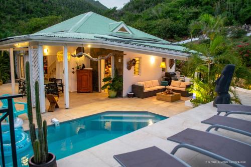 a house with a swimming pool and a patio at Villa Fleur de Pirate in Orient Bay