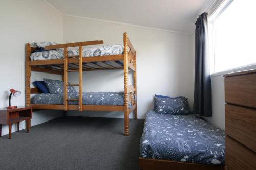 a bedroom with two bunk beds and a bed at Opunake Break - Opunake Holiday Home in Opunake