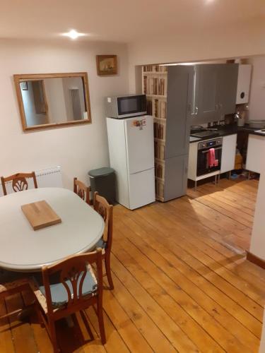 uma cozinha com uma mesa e um frigorífico branco em Characterful Cottage near the Sea, Beach, Pier & Shops em Weston-super-Mare