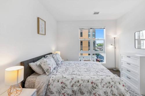 een witte slaapkamer met een bed en een raam bij Spacious sunny 2Br2Ba apartment in Boston