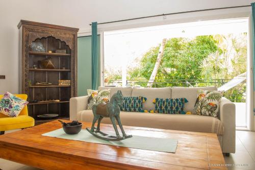 a living room with a couch and a table at Villa Fleur de Pirate in Orient Bay
