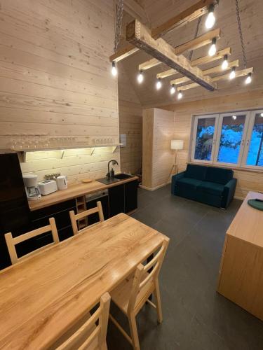 シュチルクにあるPoncyljuszówkaの木製テーブルと緑のソファが備わる客室です。