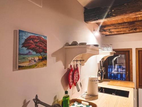 a kitchen with a red tree painting on the wall at Holy View Apartment in Bolzano