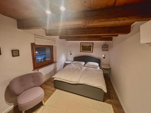 a small bedroom with a bed and a chair at Holy View Apartment in Bolzano