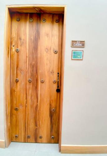 a wooden door in a building with a sign on it at Casa Hotel Bremen in Circasia