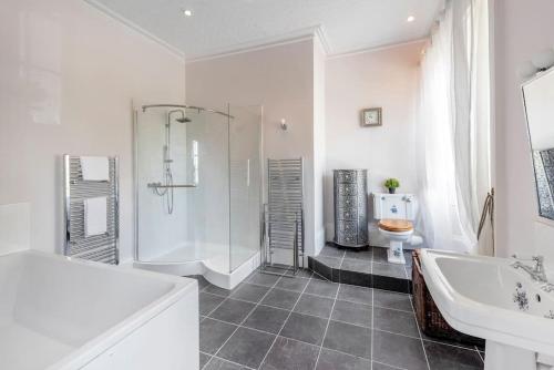 a bathroom with a shower and a tub and a sink at The Manor Holcombe Luxury House Pool & Hot-tub in Holcombe