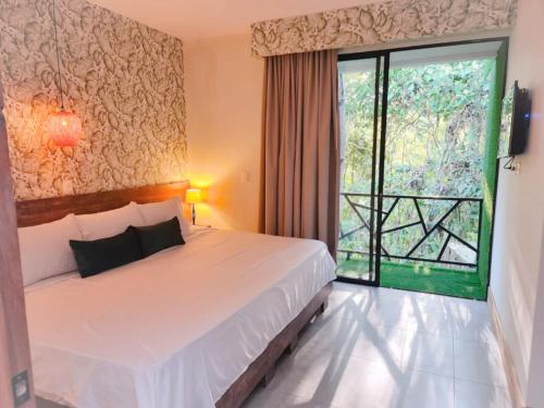 a bedroom with a bed and a large window at Casa Hotel Bremen in Circasia
