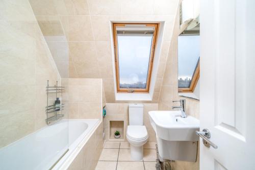 ein Badezimmer mit einem Waschbecken, einem WC und einer Badewanne in der Unterkunft Camden Town Apartment in London
