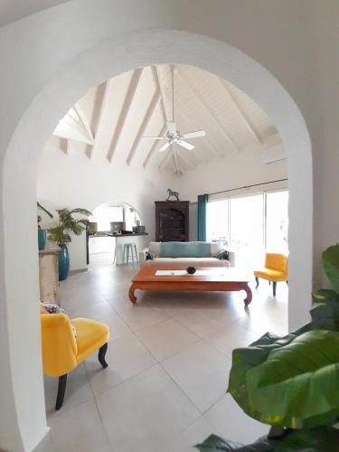 a living room with a couch and a table at Villa Fleur de Pirate in Orient Bay