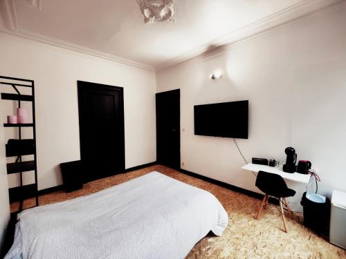 sypialnia z łóżkiem, biurkiem i telewizorem w obiekcie Private industrial room 2 in center of Charleroi w Charleroi