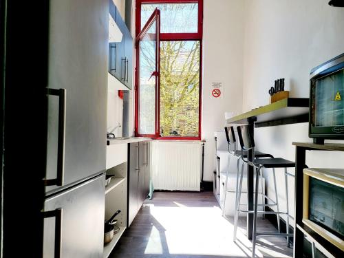 a kitchen with a window and a television in it at Private industrial room 2 in center of Charleroi in Charleroi