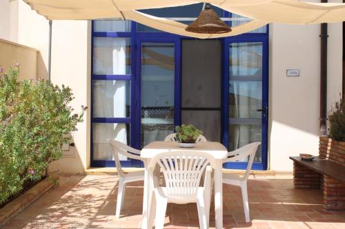 a table and chairs under an umbrella on a patio at Casa Serra in Porto Palo
