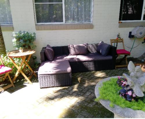 a couch sitting in a patio with a table and a table at Kincumber Guest Suite in Kincumber