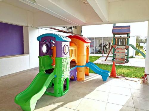 un parque infantil con un tobogán y un juego de juegos en Departamento de dos habitaciones con increíble alberca y amenidades Y-406 en Cancún