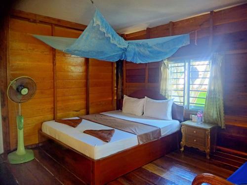 a bedroom with a bed with a blue canopy at Bunnan Bungalows and Restaurant in Koh Rong Island