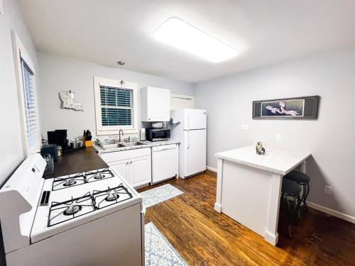 a kitchen with a stove and a white refrigerator at Unwind & Relax at Azalea Cottage on Bayou in Lafayette
