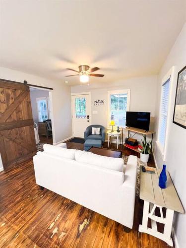 a living room with a white couch and a table at Unwind & Relax at Azalea Cottage on Bayou in Lafayette