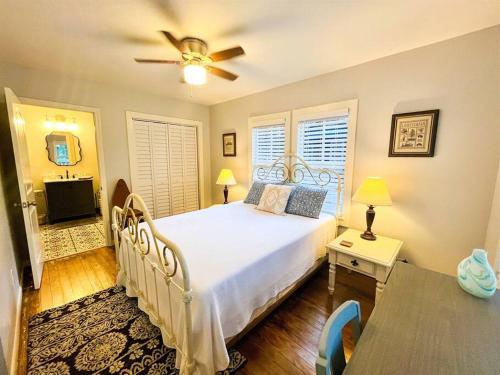 um quarto com uma cama e uma ventoinha de tecto em Unwind & Relax at Azalea Cottage on Bayou em Lafayette