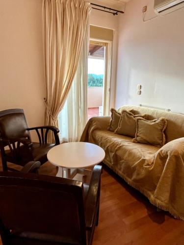 a living room with a couch and a table at Anagenessis Resort in Kalamaki