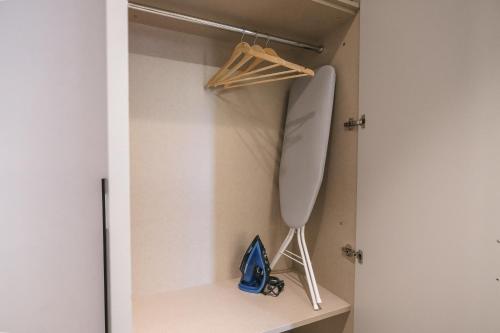 a room with a closet with a shelf and a knife at Two Steps Apartments Tirana in Tirana