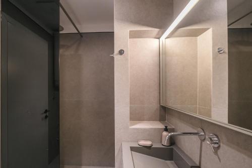 a bathroom with a sink and a mirror at Two Steps Apartments Tirana in Tirana