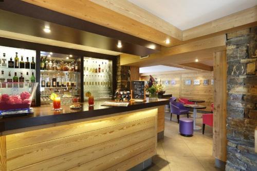 un bar dans un restaurant avec un mur en pierre dans l'établissement Les Roches 1500, à Mieussy