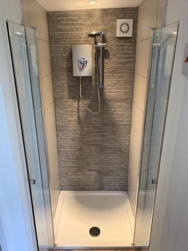 a shower with a glass door in a bathroom at The Old Beauty Room in Paulton