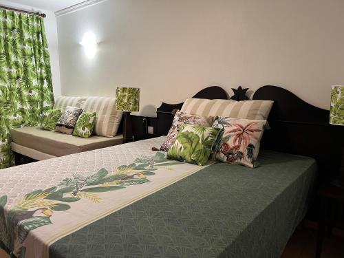une chambre avec un lit avec des oreillers dessus dans l'établissement Appartement dans RÉSIDENCE TOURISTIQUE RENOMÉE - Exceptionnel pour un Séjour de Détente, à Sainte-Anne