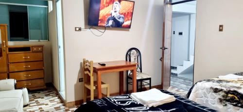a bedroom with a table and a bed and a desk at Hospedaje apus in Huaraz