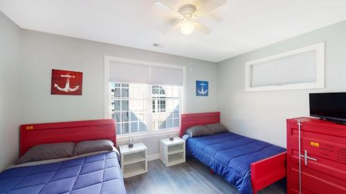a bedroom with two beds and a tv in it at Beach House Steps away from the Boardwalk and Beach with Ocean Views in Seaside Heights! in Seaside Heights