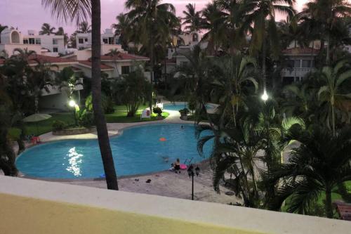 Πισίνα στο ή κοντά στο Hermoso apartamento en Manzanillo con alberca y cancha de tenis, Ideal para relajarse y disfrutar de una escapada tranquila en el paraíso tropical