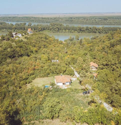 an aerial view of a house on a hill next to a river at Dunavski konaci in Brestovik