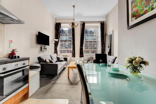 a kitchen and living room with a glass table at Unique 2 Bedroom Castle Suite Apartment - Near Edinburgh Castle & Royal Mile in Edinburgh