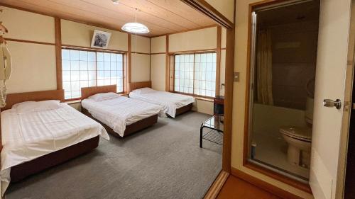 a hospital room with two beds and a toilet at irodori in Matsumoto