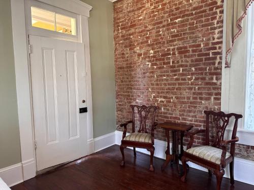 a room with two chairs and a brick wall at The Inn at Cedar Grove in Vicksburg