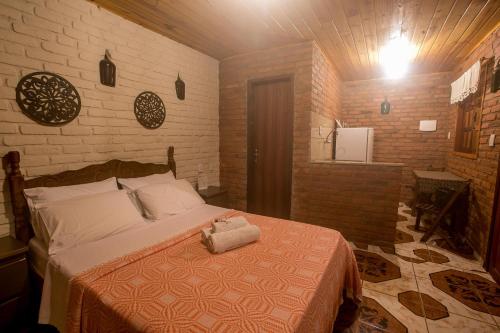 a bedroom with a bed and a brick wall at Chalés Canto da Serra in Conceição da Ibitipoca