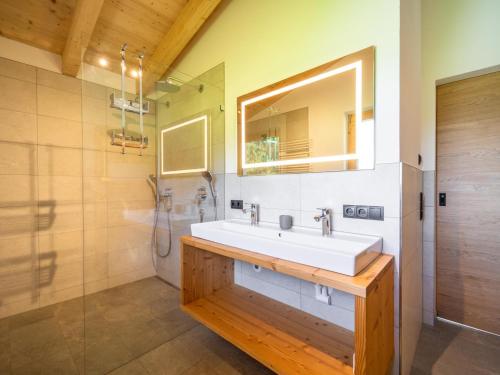 a bathroom with a sink and a shower and a mirror at Chalet Bodahof in Aschau