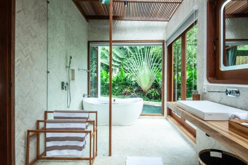 a bathroom with a tub and a sink at Paya Paya Villa Seminyak in Seminyak