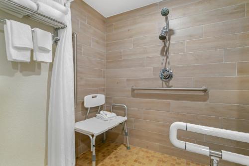 a bathroom with a shower and a bench in it at Inn on Destin Harbor, Ascend Hotel Collection in Destin