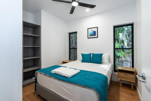 um quarto com uma cama e uma janela em Kipara Tropical Rainforest Retreat em Airlie Beach