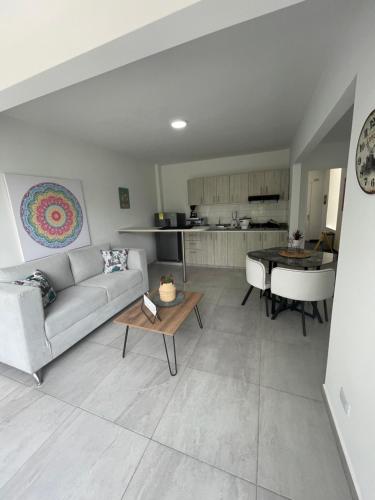 a living room with a couch and a table and a piano at Ingenio Park 83 - Apartahotel in Cali